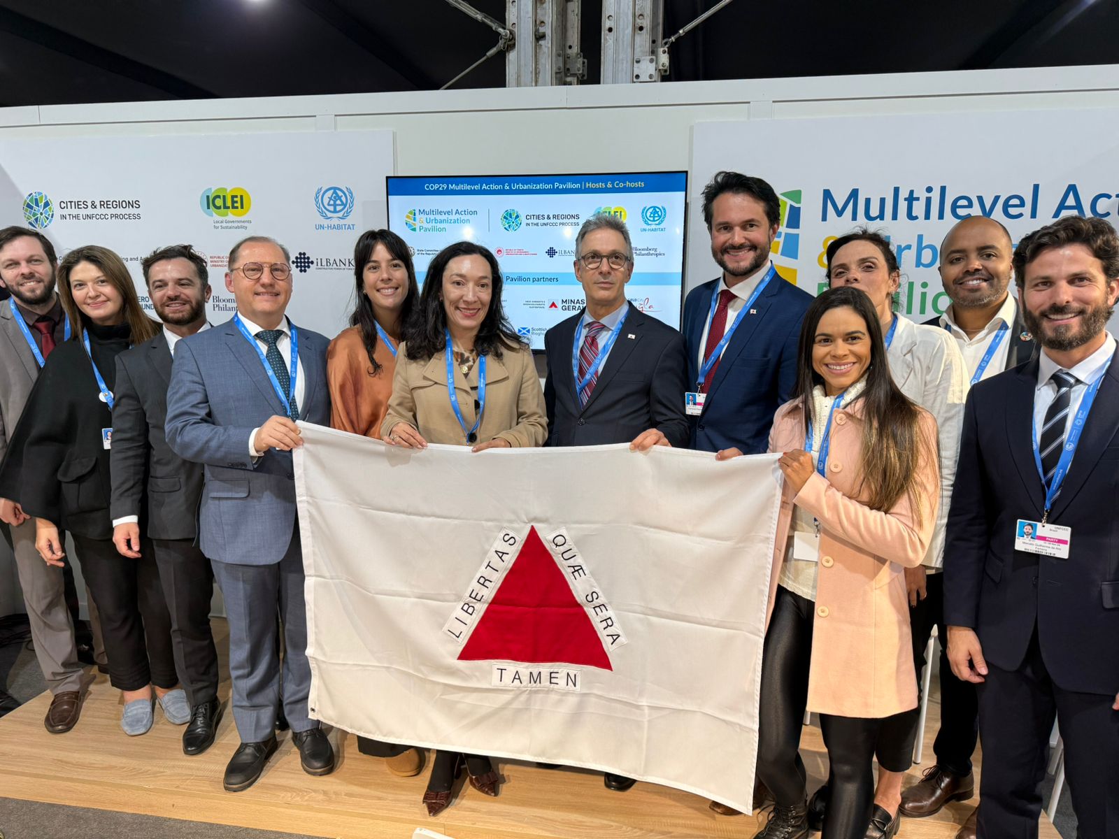 várias pessoas segurando a bandeira do estado de Minas Gerais